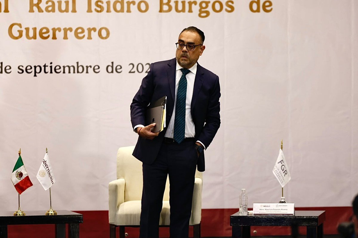 Mauricio Pazarán, head of the special Ayotzinapa prosecution unit, stands on stage holding a tablet and papers at the Sept. 28, 2026 report