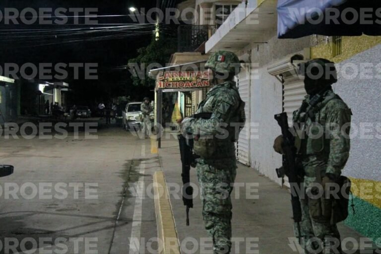 Armed Mexican Army soldiers stand guard on Juan de la Cabada street in Culiacán's 5 de Febrero neighborhood at night after the Sept. 29 shooting