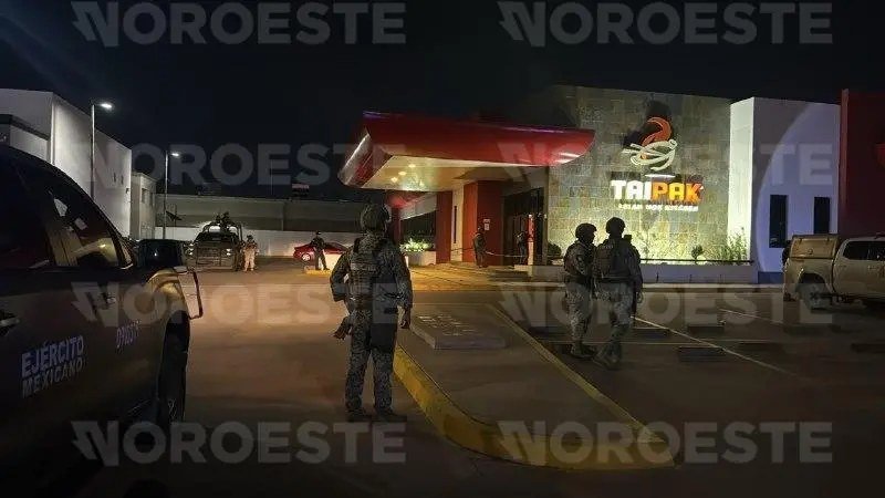 Mexican Army soldiers stand guard in the parking lot of the TaiPak restaurant in Culiacán at night