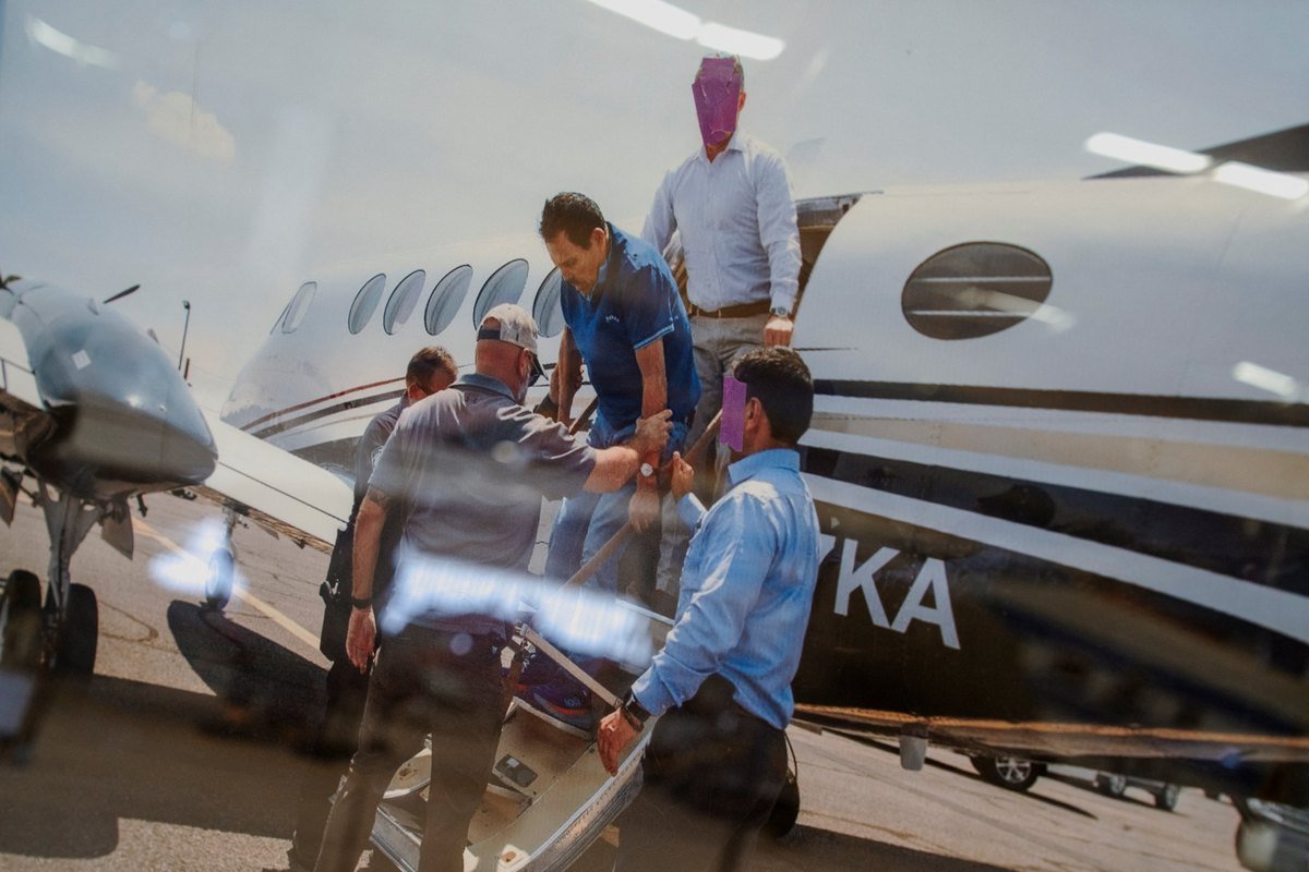 Displayed photograph showing Ismael 'El Mayo' Zambada being escorted by agents off a small plane in July 2024