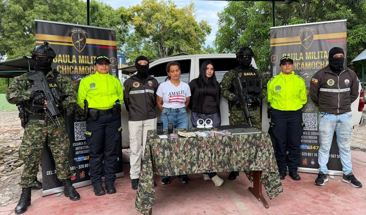 Inda Peñarrieta and Michelle Macías Peñarrieta stand between Colombian police officers, masked soldiers and Ecuadorian police behind a table of cash, radios and laptops