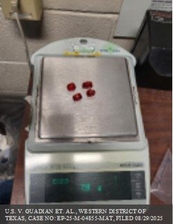 Four small red gummy candies on a digital scale in an inspection room