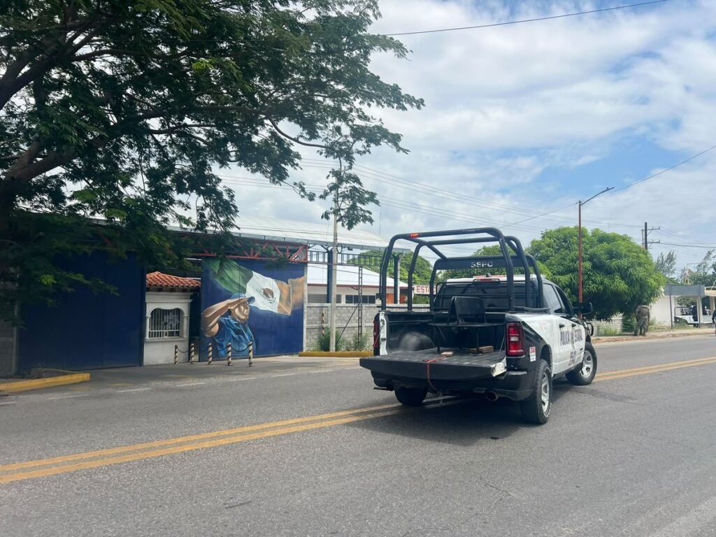 A state police pickup marked SSPC drives past the blue gates of the municipal police headquarters in Juchitán, Oaxaca, during the September 25, 2026 takeover.