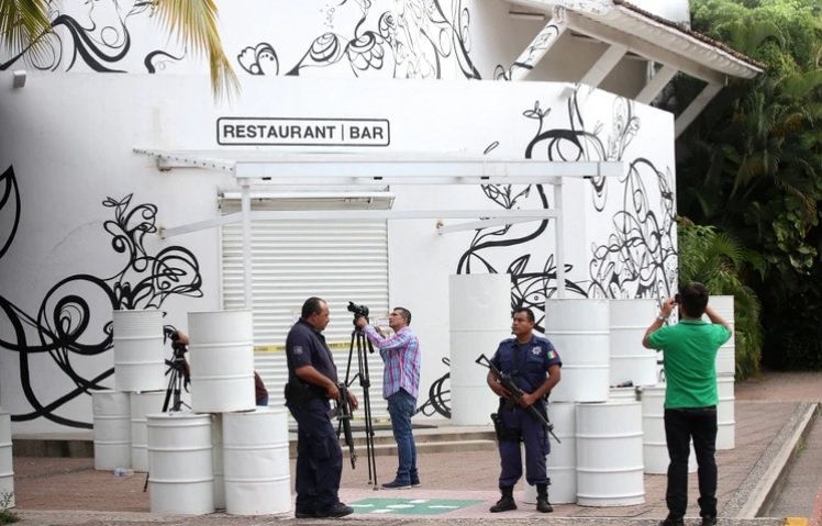 Police officers and camera crews outside the La Leche restaurant in Puerto Vallarta after the August 2016 kidnapping of El Chapo's sons