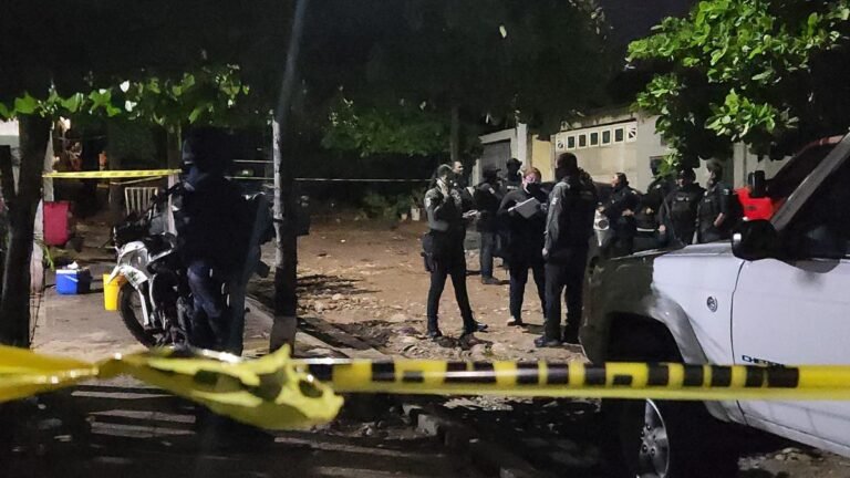 Security personnel behind crime-scene tape outside a home in the Monte Sierra neighborhood of Culiacán after the Sept. 27, 2026 shooting