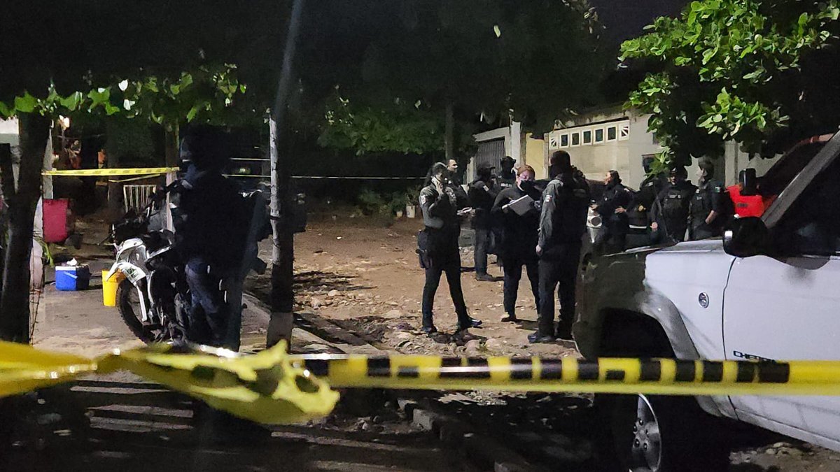 Security personnel behind crime-scene tape outside a home in the Monte Sierra neighborhood of Culiacán after the Sept. 27, 2026 shooting