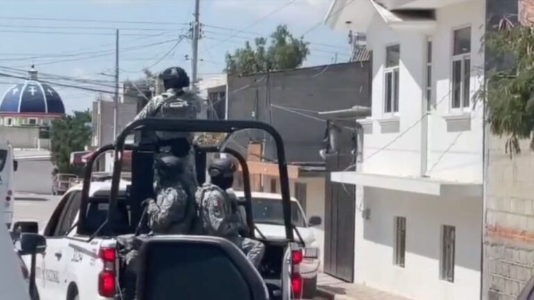 National Guard troops ride in the back of a patrol pickup on a residential street in Tecamachalco, Puebla, during the wake for the mayor's son.