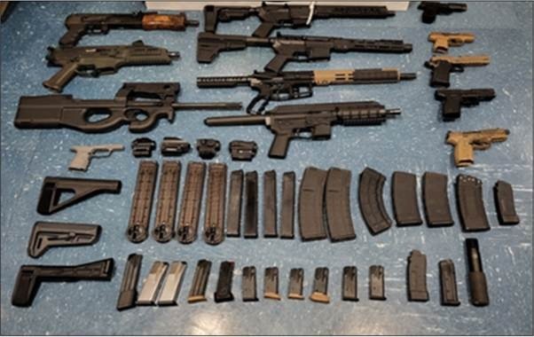 Rifles, pistols, rifle stocks and dozens of magazines laid out on a floor after a CBP seizure of Mexico-bound firearms
