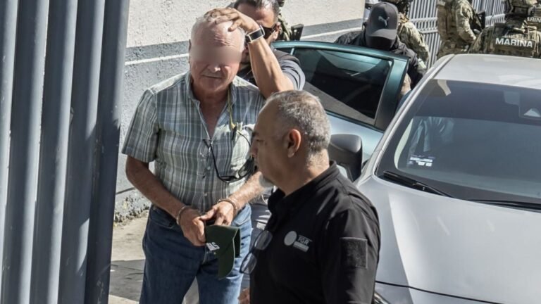Former Baja California governor Ernesto Ruffo Appel, in a plaid shirt, escorted by federal agents outside the FGR office in Tijuana