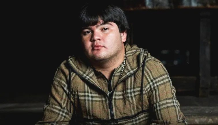 Portrait of singer Víctor Valverde wearing a plaid hooded jacket