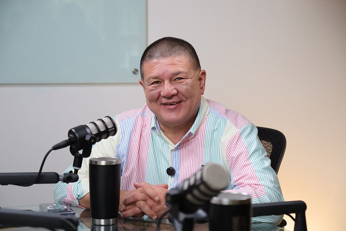 César Jáuregui Moreno smiling at a table with microphones during an interview in July 2026