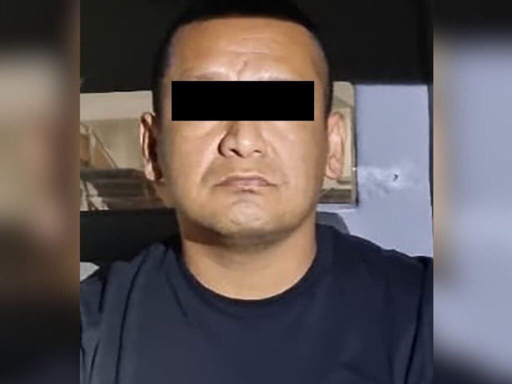 Iván Cazarín Molina, “El Tanque,” eyes blacked out, in a dark navy T-shirt, photographed after his arrest