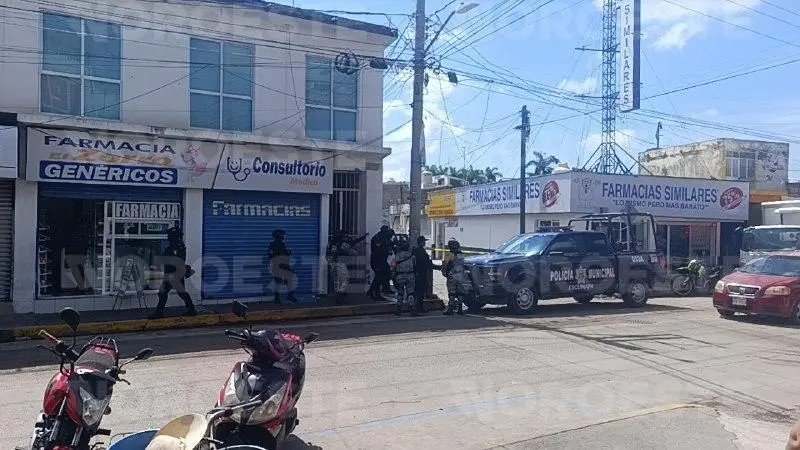 Soldiers, National Guard and municipal police outside pharmacies on a downtown Escuinapa street behind crime-scene tape