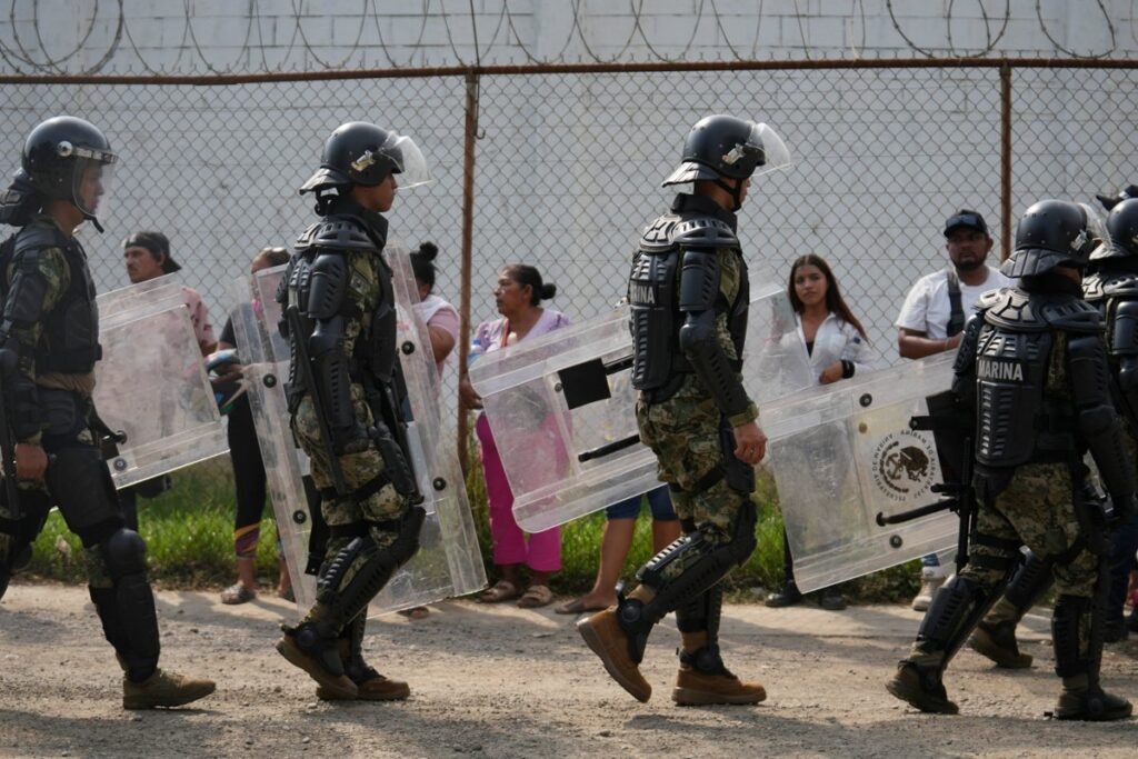 Mexican Navy riot troops with shields walk past relatives waiting outside El Castillo prison in Mazatlán, Sinaloa, on Oct. 8, 2026