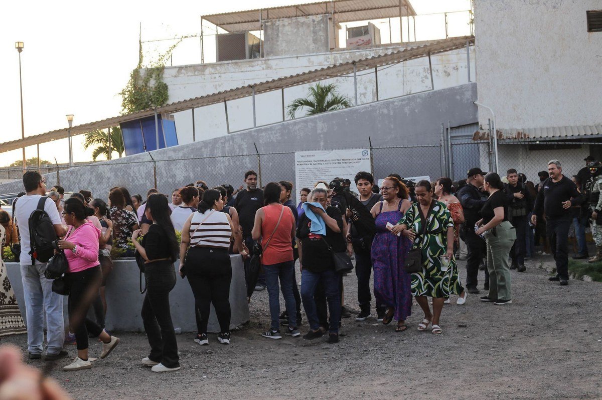 Relatives of inmates, mostly women, gather outside El Castillo prison in Mazatlán as police and soldiers stand nearby